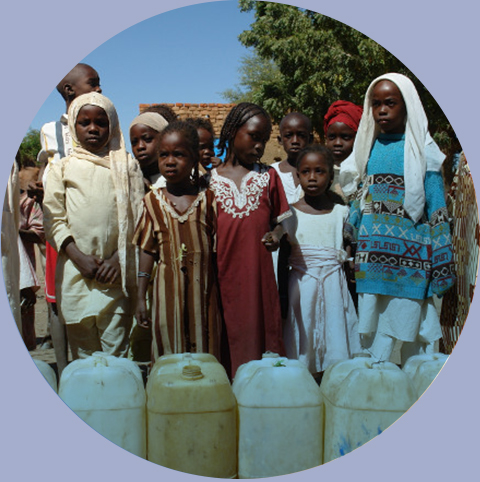 Grupa dzieci czeka wzdłuż ustawionych kanistrów na wodę podczas wojny i suszy, Darfur, Sudan Afryka, 2008 rok.